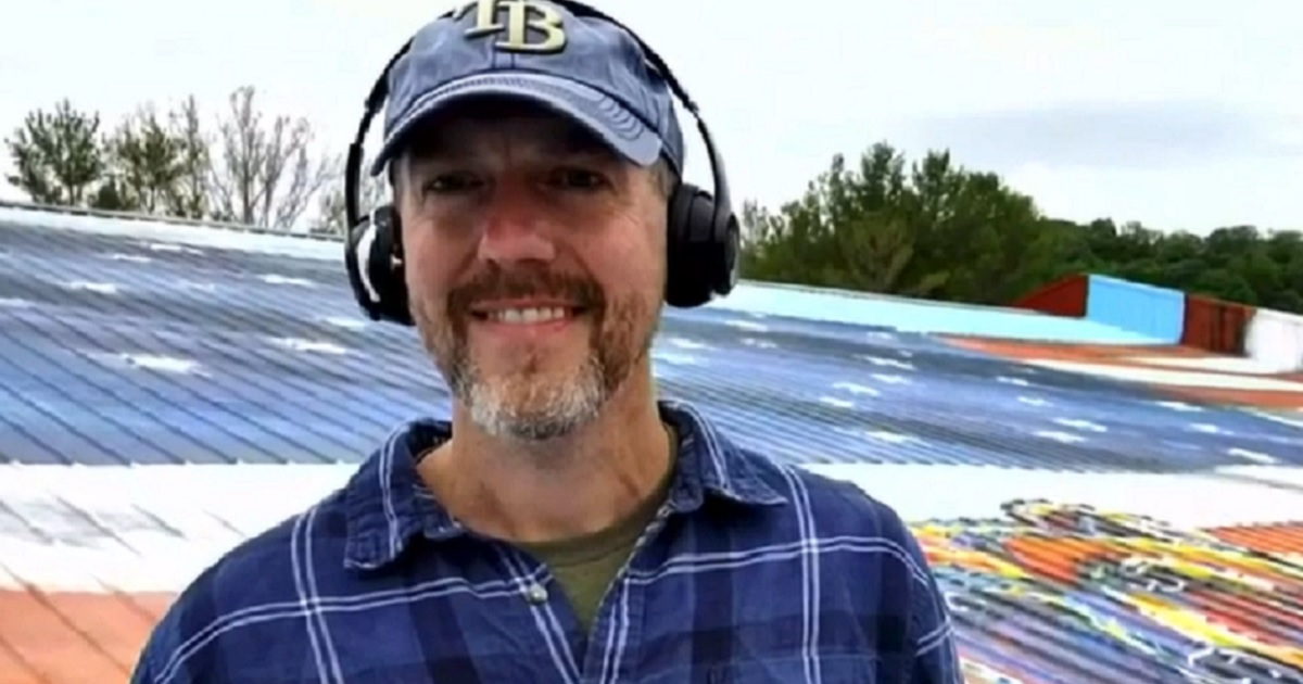 Painter Adam Long is interviewed on the roof of Bear Hardware in Nashville, Indiana.