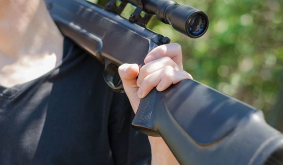 A man holds a rifle in this stock image.