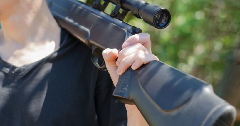 A man holds a rifle in this stock image.