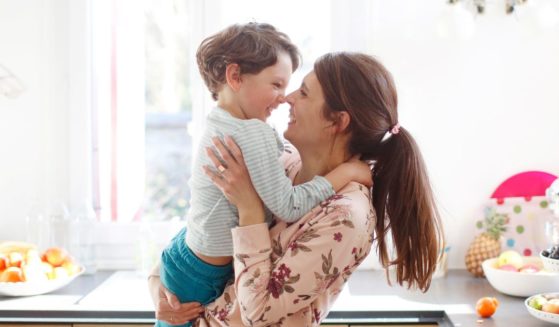 A mother holds her son in the above stock image.