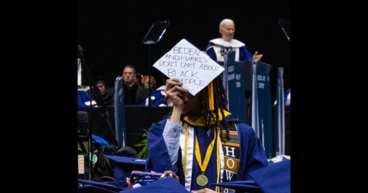 A graduating student at Howard University holds up a sign during President Joe Biden's speech Saturday.