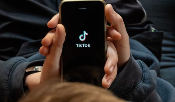 In this photo illustration, a boy looks at the TikTok app on a smartphone screen.