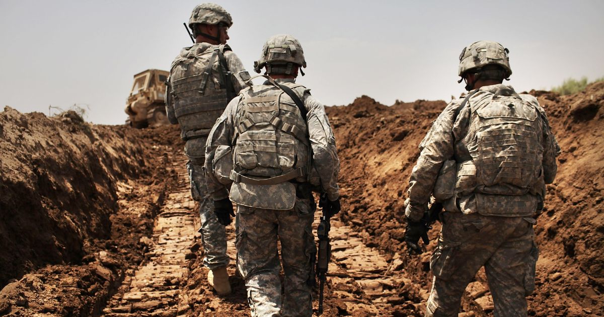 U.S. soldiers with the 3rd Armored Cavalry Regiment patrol a new ditch they have dug to protect the base from attack on July 19, 2011, in Iskandariya, Babil Province Iraq.