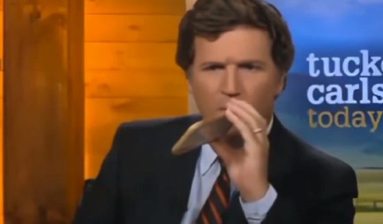 Tucker Carlson is pictued talking on a cell phone on the set of "Tucker Carlson Today."