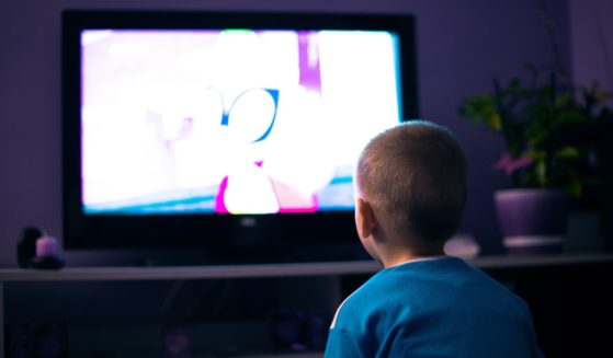 A boy watches TV in this stock image.