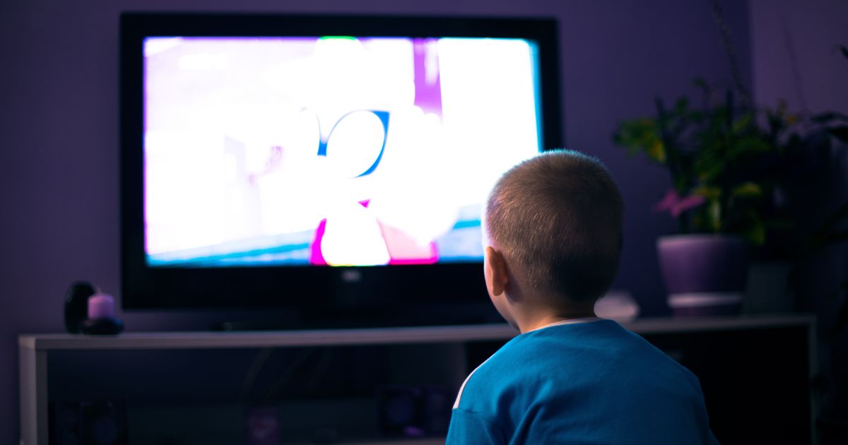 A boy watches TV in this stock image.