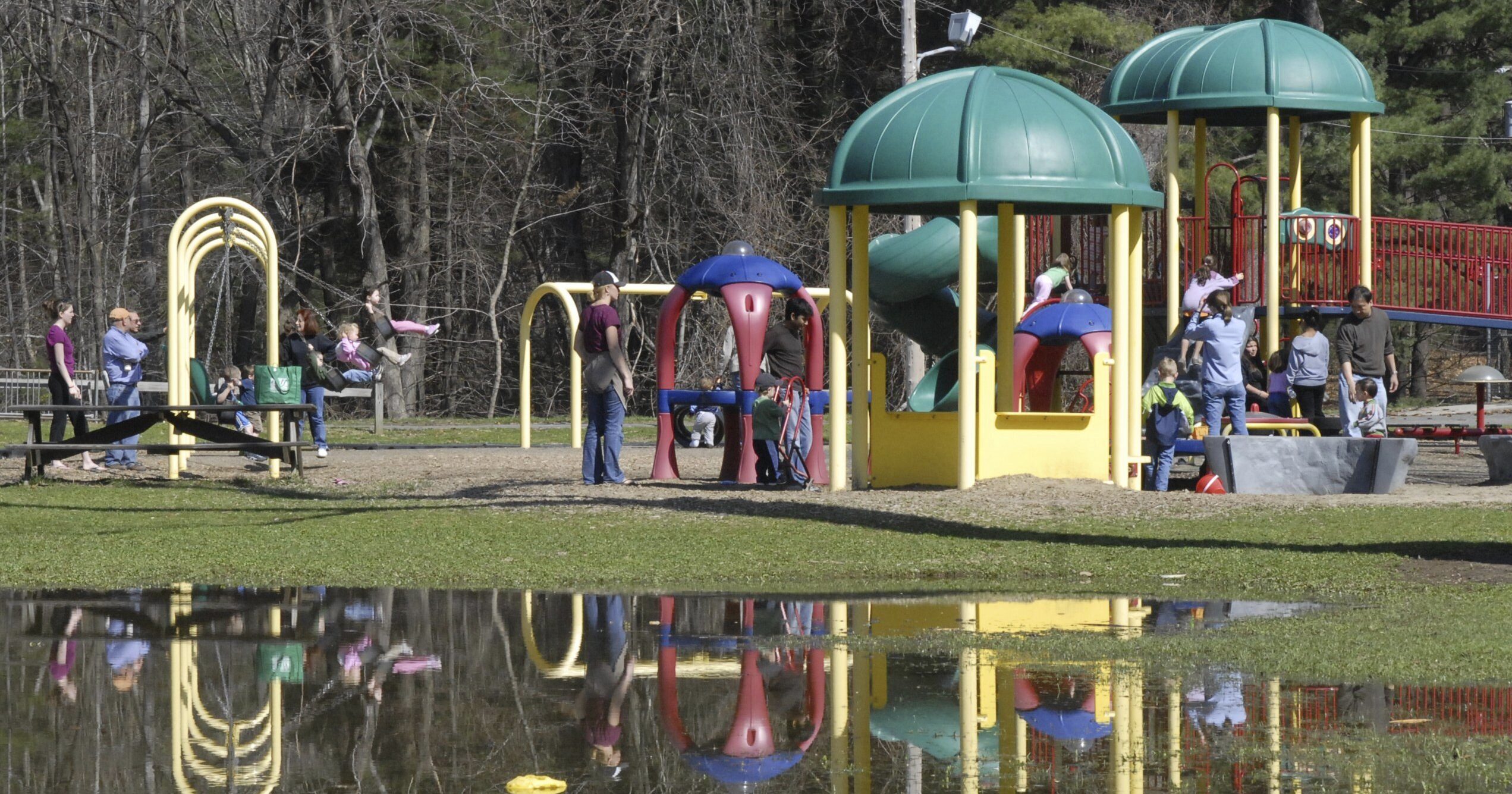 The playground at Bliss Park in Longmeadow, Massachusetts, is reflected in standing water in an April 2, 2010, file photo.