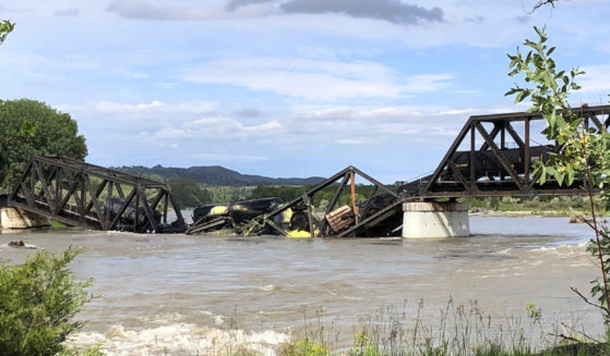 Train cars are immersed in the Yellowstone River after a bridge collapse near Columbus, Montana, on Saturday.