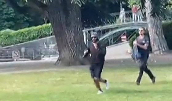 A screen grab taken from a video obtained by AFPTV shows a man armed with a knife running away after he attacked a group of preschool children playing by a lake in the French Alps city of Annecy on Thursday. The suspect is a Syrian in his early 30s who was granted refugee status in Sweden in April, a police source told AFP.