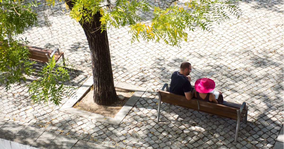 A couple sit on a bench close by the Main Church of Saint Mary of the Castle in Tavira, Portugal, on Sept. 18, 2022.