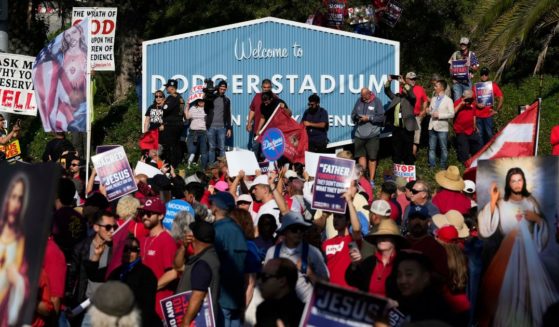 Protesters rally outside Dodger Stadium in Los Angeles after a prayer service Friday.