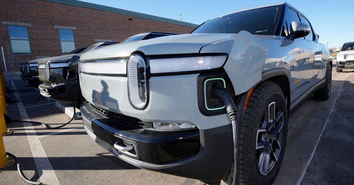 A 2023 R1T pickup truck is charged in a bay at a Rivian delivery and service center on Feb. 8 in Denver.