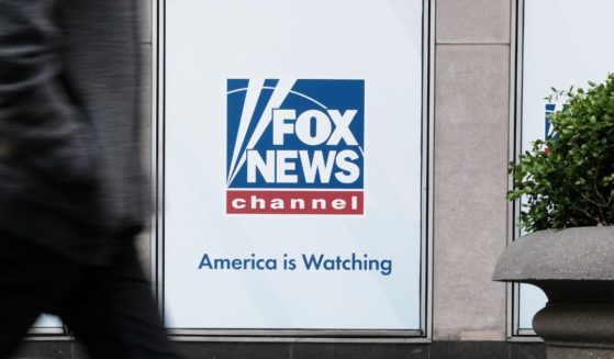 People walk by the News Corporation headquarters, home to Fox News, in New York City on April 18.