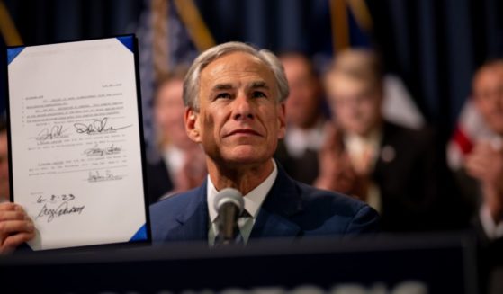 Texas Gov. Greg Abbott displays a signed bill, which is designated towards enhancing border security along the southern border, during a news conference in Austin, Texas, on Thursday.