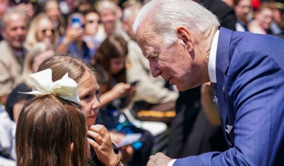 President Joe Biden talks to two girls after delivering remarks during the National Peace Officers Memorial Service at the U.S. Capitol in Washington, D.C., on May 15, 2022.