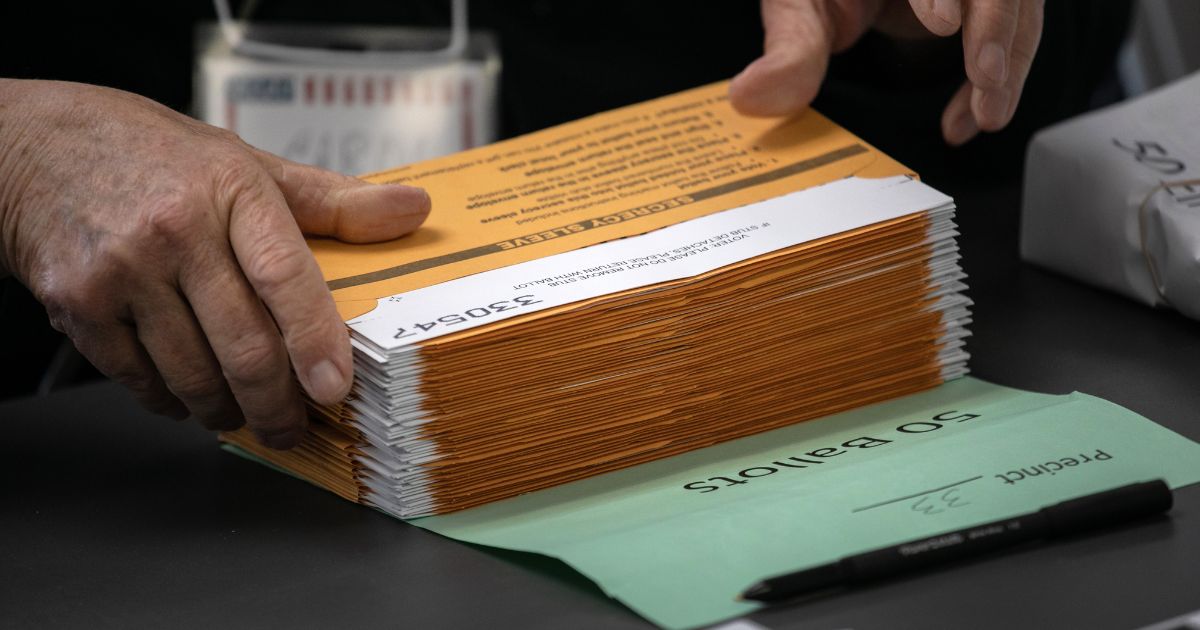 An election worker sorts absentee ballot envelopes at the Lansing City Clerk's office in Lansing, Michigan, on Nov. 2, 2020.