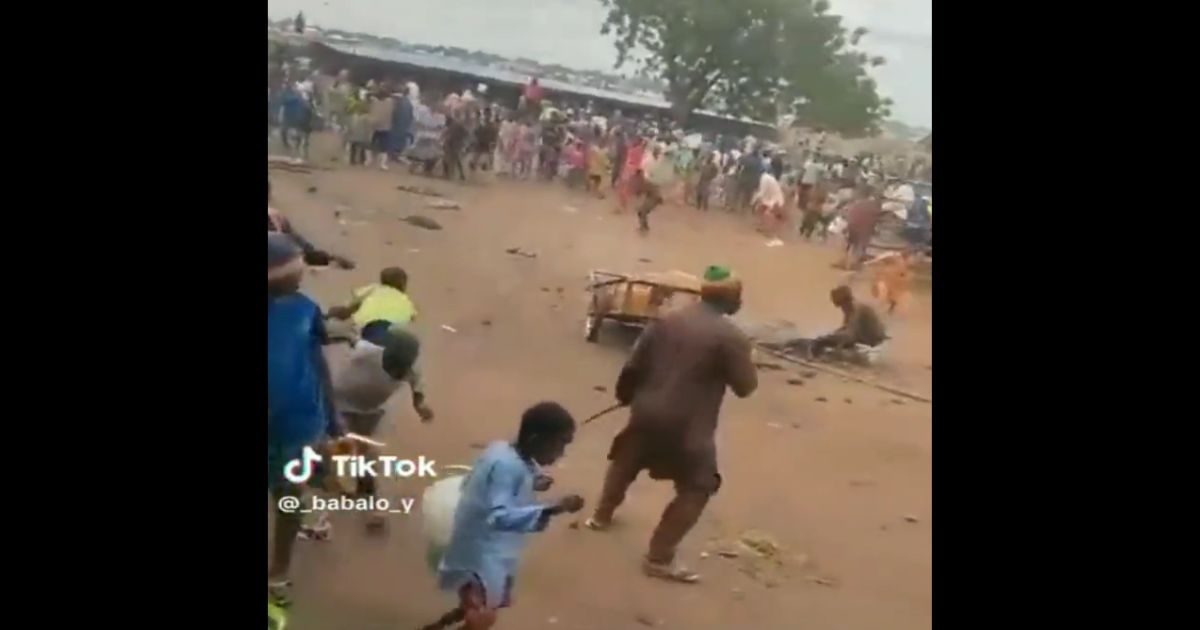 A Muslim mob that includes children throws stones at a man accused of blasphemy in Nigeria.