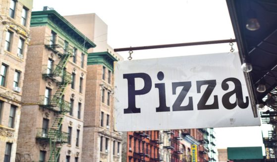 A pizza sign hangs outside a restaurant in New York City in an undated stock photo.