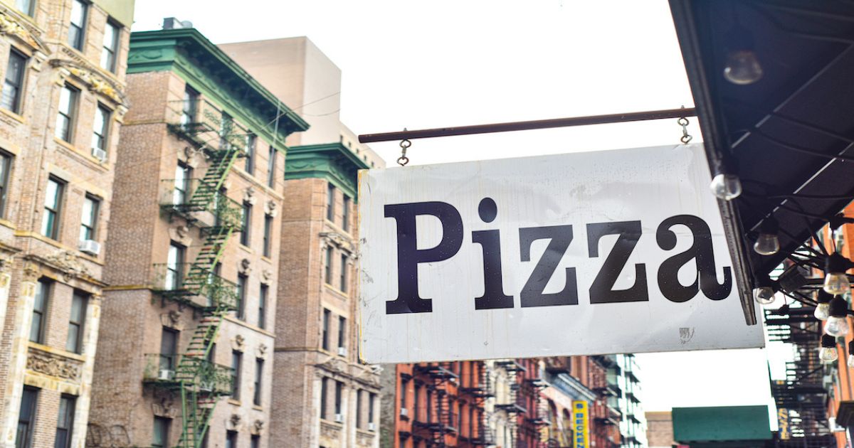 A pizza sign hangs outside a restaurant in New York City in an undated stock photo.