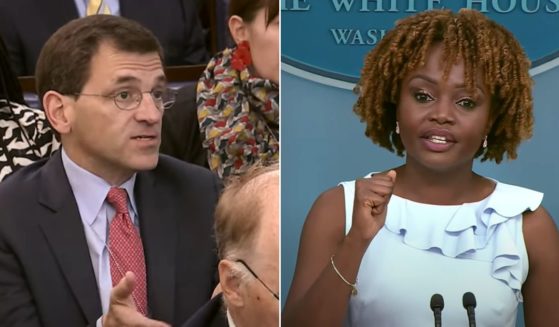 A member of the White House press corps, left, asks a question of White House press secretary Karine Jean-Pierre, right.