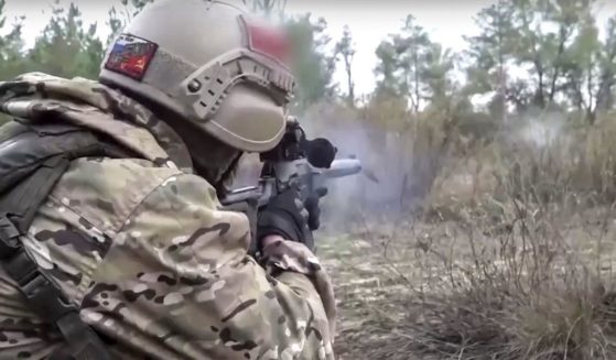 In a photo released by Russian Defense Ministry Press Service on Oct. 19, 2022, a Russian soldier fires with a sniper rifle during an action at an unspecified location in Ukraine.