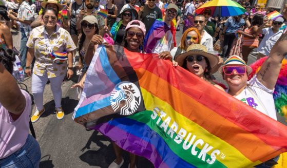 Marchers carry an LGBT-themed Starbucks flag during the annual "pride" parade on June 12, 2022, in Los Angeles.