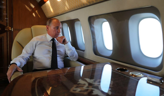 Russian President Vladimir Putin is pictured aboard the presidential plane in a file photo from December 2017. Putin's plane was reportedly seen taking off from Moscow Saturday, though officials insist he remains in the capital city and is working from the Kremlin.