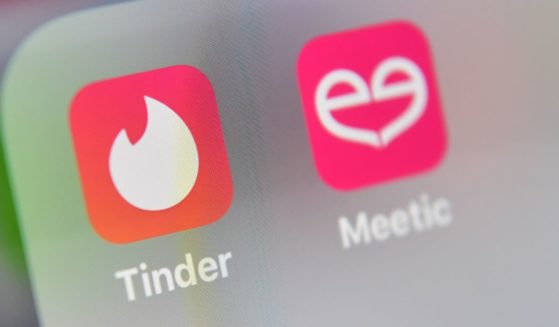 An illustration picture of the logo of the US social networking application Tinder and French application Meetic on the screen of a tablet, taken on May 5, 2020.