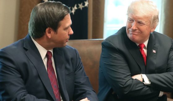 Florida Gov.-elect Ron DeSantis sits next to then-President Donald Trump during a meeting with elected governors in the Cabinet Room at the White House on Dec. 13, 2018.