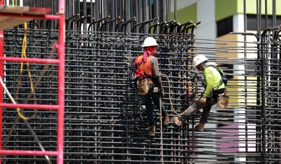 Construction crew members work on a job site in Miami on May 5.