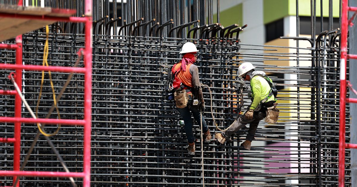 Construction crew members work on a job site in Miami on May 5.