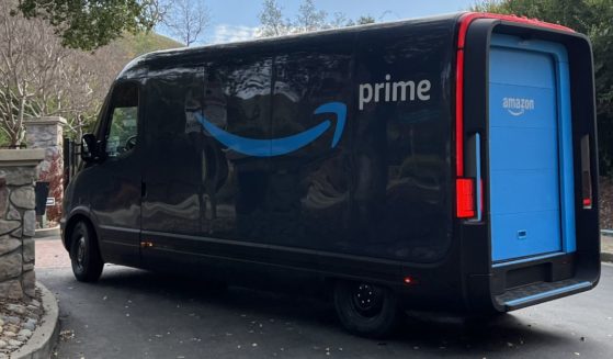An Amazon electric delivery truck, developed by electric vehicle maker Rivian, makes deliveries in a residential neighborhood in Lafayette, California, with the Amazon Prime logo visible.
