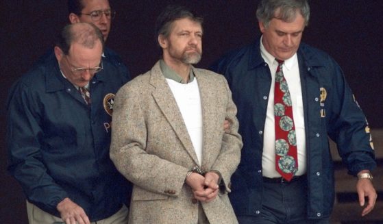 Theodore Kaczynski looks around as U.S. Marshals prepare to take him down the steps at the federal courthouse in Helena, Montana, to a waiting vehicle in a file photo from June 21, 1996. A spokesperson for the Bureau of Prisons told The Associated Press that Kaczynski, known as the “Unabomber,” has died in federal prison.
