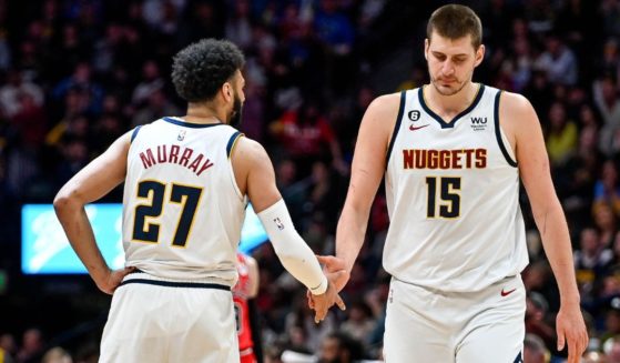 Nikola Jokic, right, and Jamal Murray, left, of the Denver Nuggets slap hands after a second half score against the Chicago Bulls at Ball Arena on March 8 in Denver.