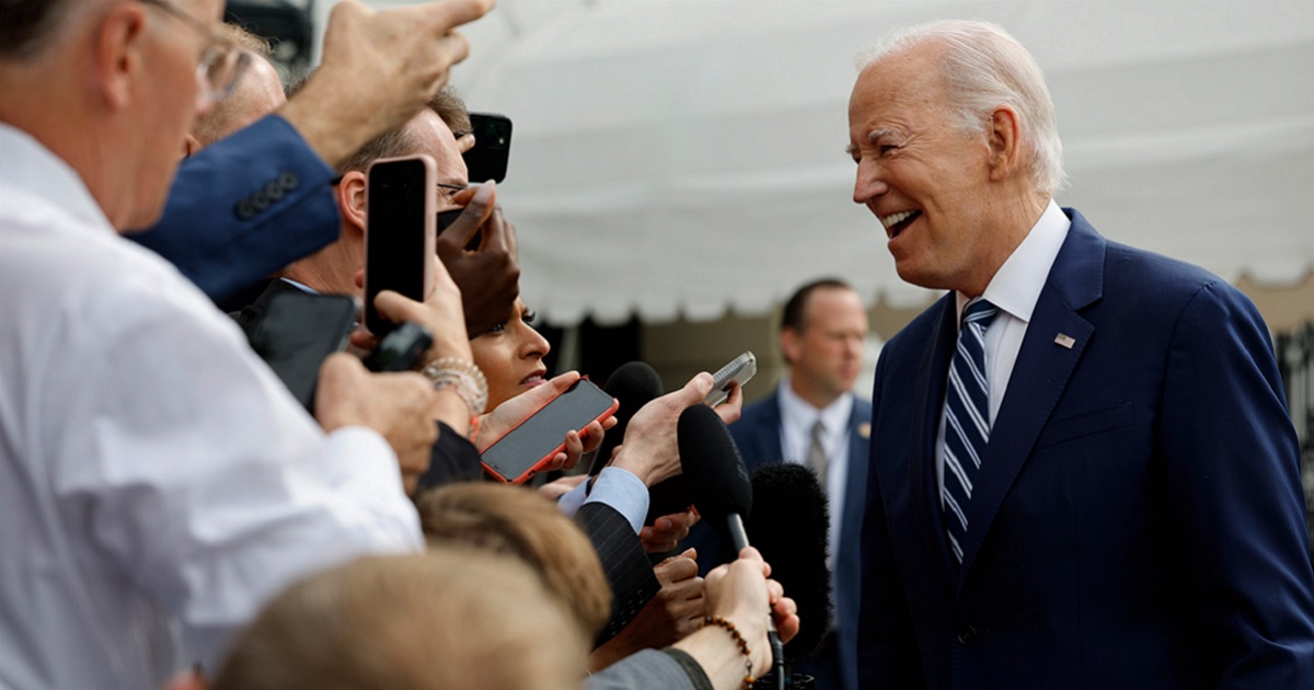 President Joe Biden smiles while talking to reporters outside the White House on Wednesday.