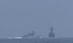 A Chinese naval vessell, left, heads toward overtaking and cutting off an American destroyer in the Taiwan Strait on Saturday.