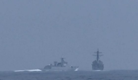 A Chinese naval vessell, left, heads toward overtaking and cutting off an American destroyer in the Taiwan Strait on Saturday.