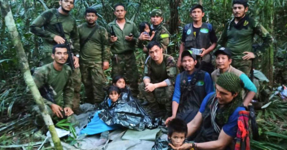 In this photo released by Colombia's Armed Forces Press Office, soldiers and Indigenous men pose for a photo with the four Indigenous children who were missing after a deadly plane crash, in the Solano jungle, Caqueta state, Colombia, on Friday.