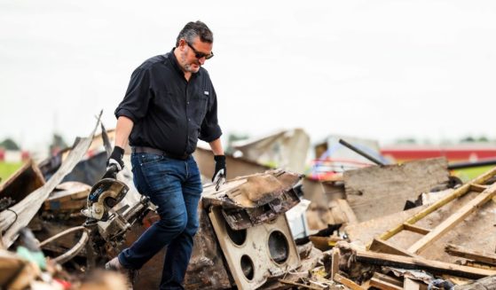 Sen. Ted Cruz of Texas carries an item from debris in a trailer park that was damaged by a tornado in Perryton, Texas, on Saturday.