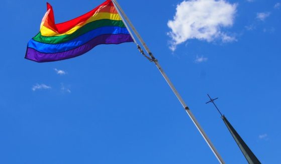 A rainbow flag flies in front of a church in this stock image.