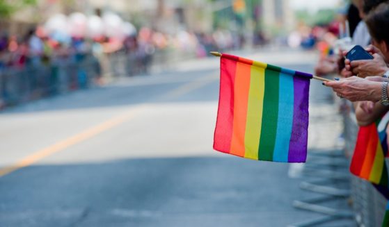A woman holds a rainbow flag in this stock image.