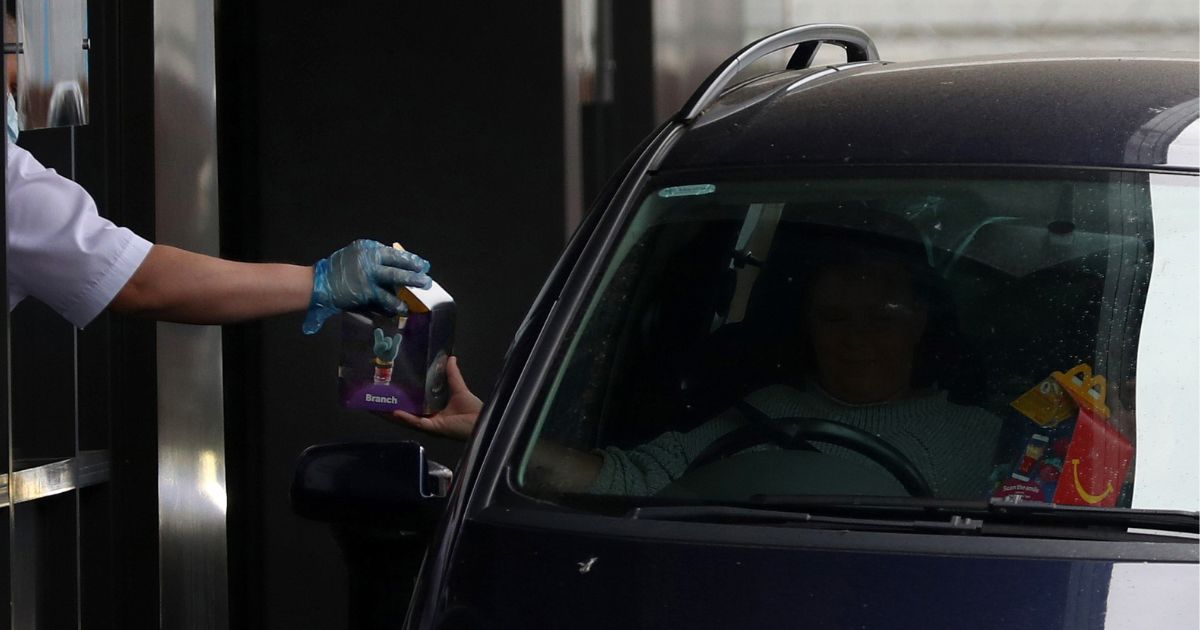 A member of the public receives his McDonald's Happy Meal order as the drive thru resumes trading on June 3, 2020 in Aylesbury, United Kingdom.