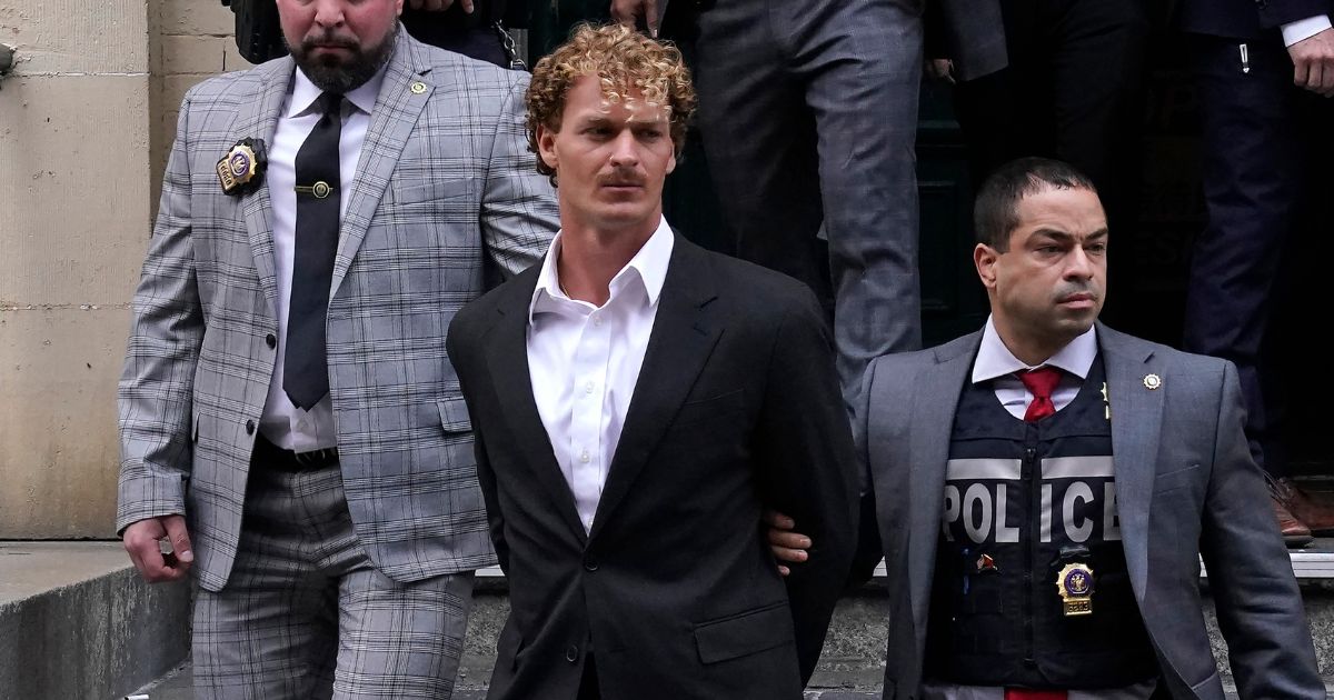 Marine veteran Daniel Penny (C) is walked out of the New York Police Department 5th Precinct in Lower Manhattan, on May 12 on his way to an arraignment after he surrendered to authorities.