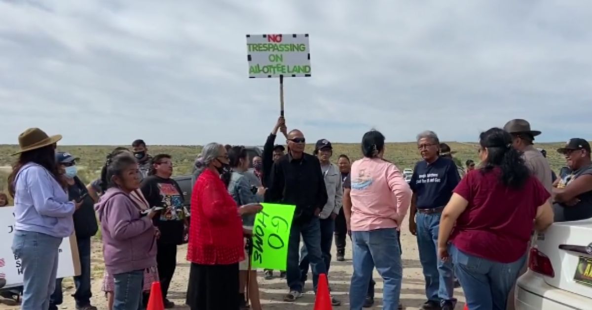 Individuals are seen protesting President Joe Biden's drilling ban.