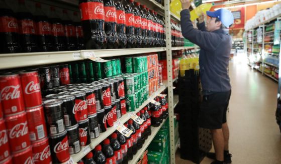 A worker re-stocks sodas on March 19, 2020, in Los Angeles.
