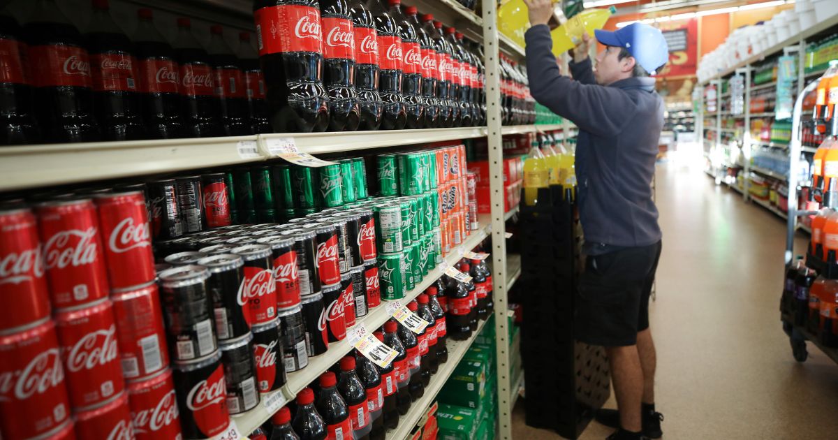 A worker re-stocks sodas on March 19, 2020, in Los Angeles.