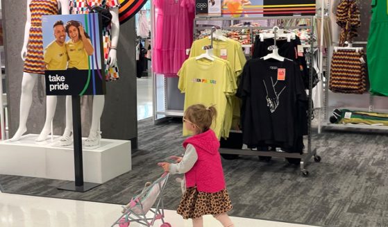 A young girl pushes a toy stroller past a "pride month" merchandise display at a Target store on May 31 in San Francisco.
