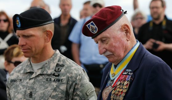 Command Sgt Major Retired Bill Ryan (R), who landed at Omaha Beach 70 years ago tomorrow, with current Division Sgt. Major Michael Grinston (L) during a moment of silence for fallen colleagues at a ceremony honoring the First Infantry Division's actions on D-Day on Omaha Beach June 5, 2014, in Colleville-sur-Mer, France.