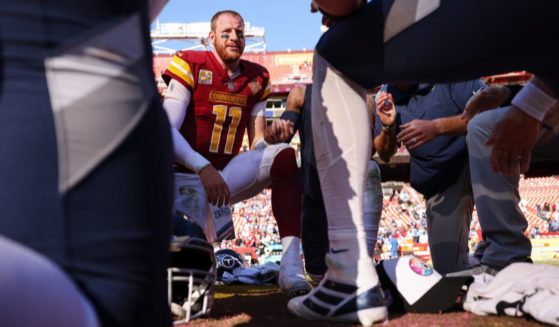Carson Wentz #11 of the Washington Commanders prays with players on the field after the game against the Tennessee Titans at FedExField on October 9, 2022 in Landover, Maryland.