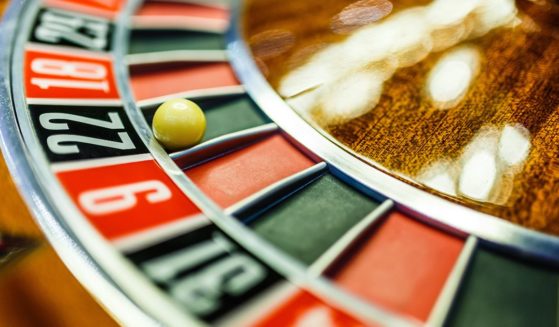 A ball rests on a roulette wheel in the above stock image.